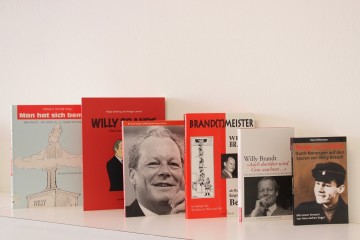 Aufreihung verschiedener Buchcover: „Man hat sich bemüht“, „Willy Brandt. Eine Comic-Biografie“, „Willy Brandt – Ein politisches Leben im 20. Jahrhundert“, „Brand(t)meister“, „Auch darüber wird Gras wachsen…“ und „Nroge med Willy. Durch Norwegen auf den Spuren von Willy Brandt“. Öffnet eine Liste mit Veröffentlichungen über Willy Brandt.
