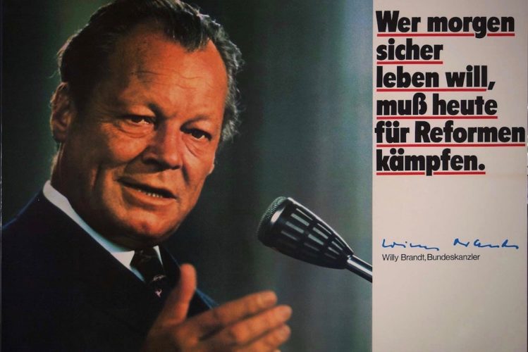 Wahlkampfplakat 1972 auf dem links ein Porträt von Willy Brandt mit einem Mikrofon zu sehen ist und Rechts der schwarze Text auf weißem Hintergrund und rot unterstrichen steht: Wer morgen sicher leben will, muss heute für Reformen kämpfen. Darunter die Unterschrift Willy Brandts, Bundeskanzler.